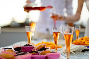Bride and groom preparing for the bachelorette party pour white wine into glasses