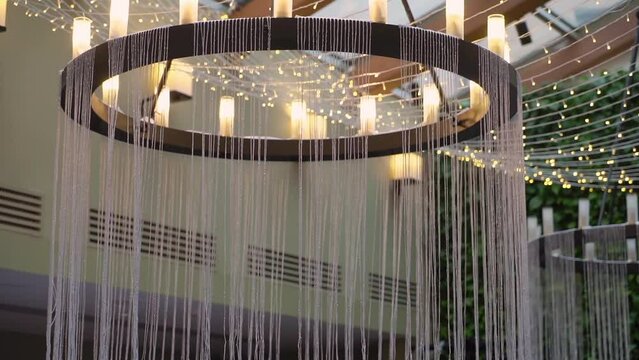 Interior light lamps luxury chandelier hanging on ceiling of luxurious restaurant, hotel or palace. Modern golden color.