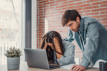 Mad millennial couple frustrated with slow Internet connection paying bills online at home,...