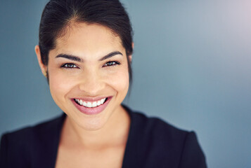 Fototapeta premium Studio, business and face of woman, confident and professional with pride, USA and lawyer. Blue background, student and smile of person, internship and career in law firm for financial advisor