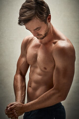 Fototapeta premium Confident, man and flex with abs in studio background for healthy body, workout and exercise. Male person, muscle and shirtless isolated on backdrop for fitness, confidence and training with six pack