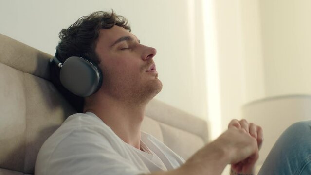 Caucasian European man listening music headphones technology sing home bedroom earphones gadget weekend digital leisure relaxation device sound tune gesture song rhythm lifestyle mp3 headset playlist