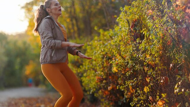 Hello autumn. modern female in fitness clothes in the park training.
