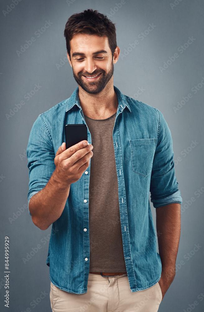 Poster cellphone, smile and read with man in studio, communication and social media on gray background. int