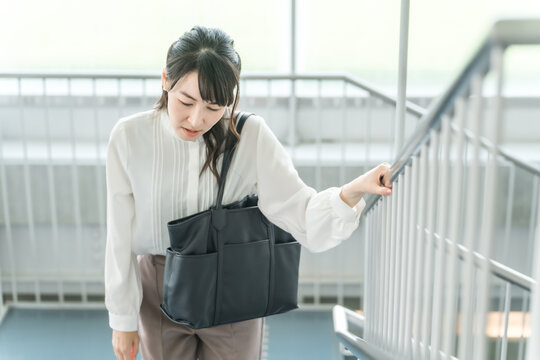 階段を上る疲れ果てたビジネスウーマン（疲労・残業・ブラック企業・ストレス・病気・過労）
