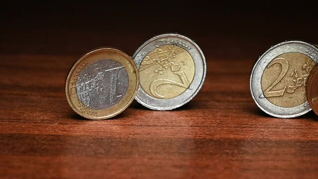 Euro coins roll across the table
