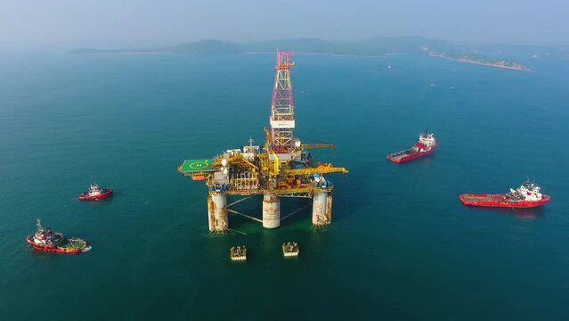 Aerial view from a drone of an offshore jack up rig at the offshore location during daytime. Oil rig drilling platform in the sea.
