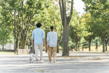 Fototapeta premium 犬の散歩をする夫婦・愛犬家・飼い主・ペットシッター・家族 