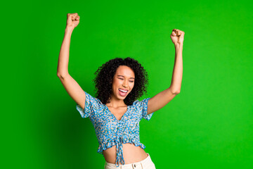 Photo of nice young woman raise fists wear top isolated on green color background