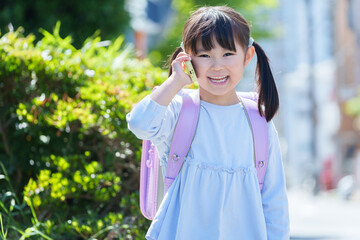 Fototapeta premium キッズケータイを使う小学生