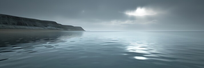 Fototapeta premium A wide shot of a calm sea with a distant cliff and a misty sky