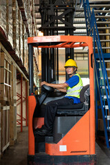 Asian senior man driving forklift truck delivery box to cargo shipping in distribution warehouse. Export import or logistics service business. employee people working in factory industrial concept