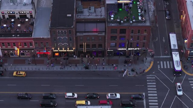 Aerial view of lively Nashville downtown Broadway street at dusk, featuring vibrant nightlife, cars, and rooftop bars. Ideal for urban and nightlife concepts
