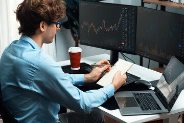 Working young professional business trader concentrating on market stock graph investing in real...