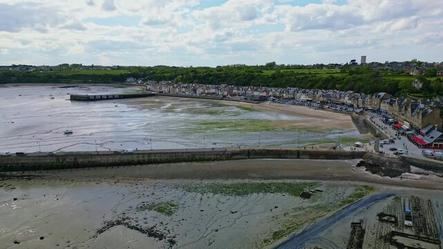 Plage de Cancale beach with Cale de la Fenetre and Cale de l'Epi piers during low tide , Brittany in France. Aerial sideways