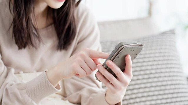 リビングでスマホを見る女性