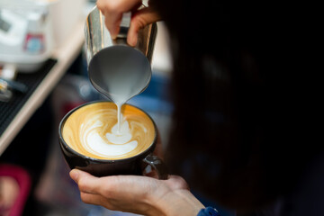 closeup hand doing hot latte art coffee