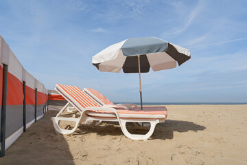 Sonnenschirm und Liegestuhl am Strand der Nordsee bei De Haan in Westflandern in Belgien