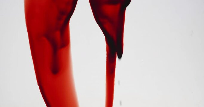 Streaks of blood pouring on a white surface, Slow motion

