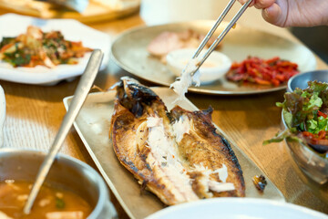 고등어 구이를 젓가락으로 집어 먹는 모습