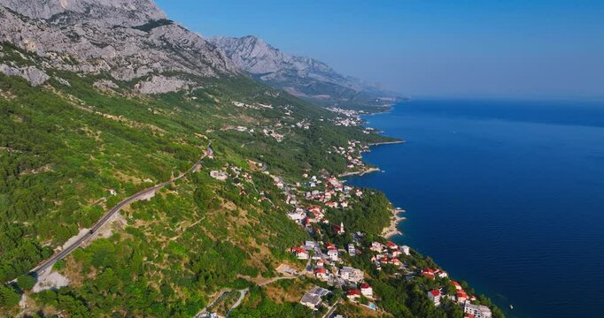 Aerial view circling towns on the Makarska riviera coastline in sunny Croatia