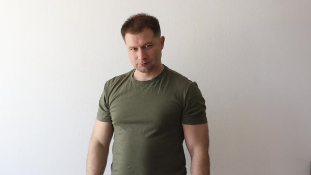 A man in a military hacky sack t-shirt salutes with his hand. 