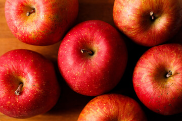 Ripe organic red apple on wooden table background.