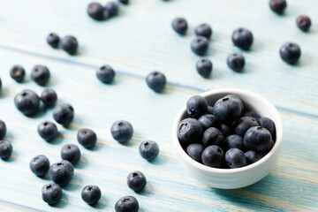 Ripe organic blueberries on blue wooden table background. Selective focus.