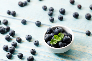 Ripe organic blueberries on blue wooden table background. Selective focus.