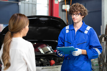 mechanic talking about how to fix a car to customer in automobile repair shop