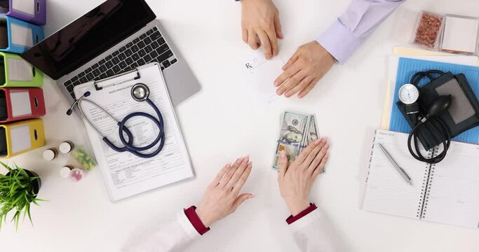 Doctor writes prescription and takes bribe top view