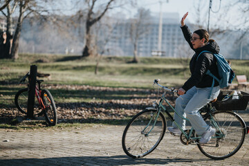 Active woman enjoying a sunny day biking in the park with backpack.