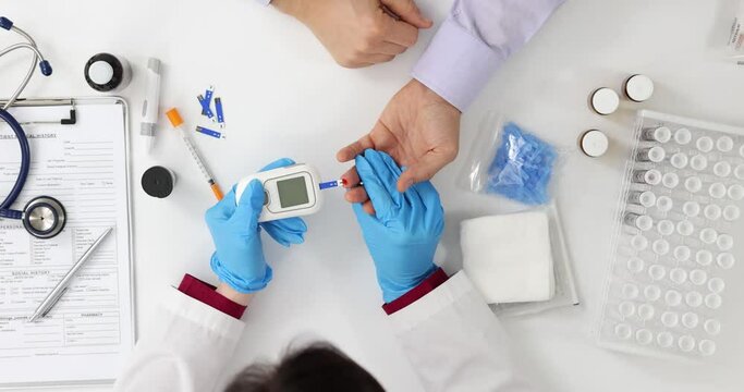 Doctor checking patient's blood sugar level top view