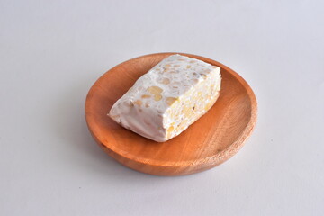 Raw Tempeh or Tempe. Tempeh Slices on Wooden White Background. Tempe Made From Fermented Soybeans