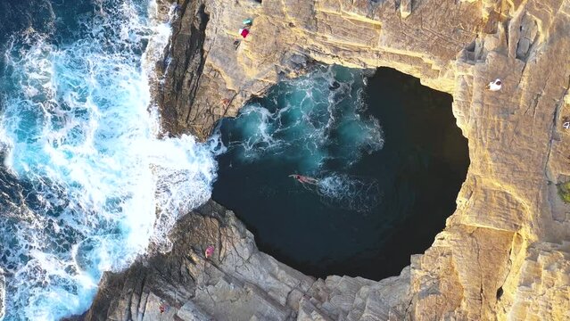 Slow motion aerial view of girl floating in Giola natural sea pool Thassos island, Greece