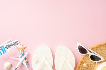 Top view of summer vacation essentials including flip flops, sunglasses, passport, plane tickets, and starfish on a pink background