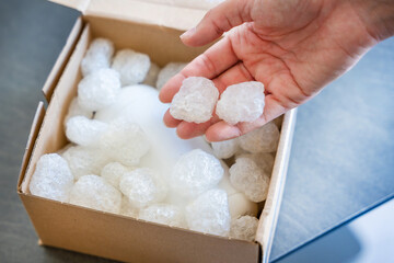 Eco packaging of parcels and white biodegradable filler. Box is filled with a filler safety for environment. Delivery of goods, parcels, delivery service, nature protection and recycling concept