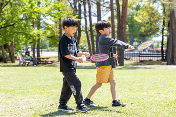 Obraz premium 公園でバトミントンを楽しむ子ども