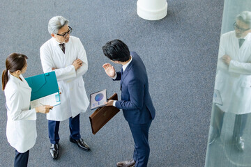 白衣の技術者に説明するビジネスマン