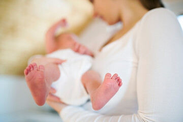 Mom holding newborn baby, looking at infant lovingly. Unconditional paternal love, Mother's Day concept.