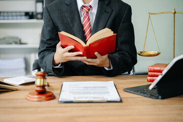 Woman lawyer reading legal book with gavel on table in office. justice and law ,attorney concept.