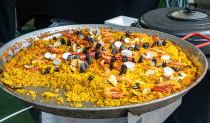 Seafood paella, Spanish rice dish with shrimp, mussels, clams, yellow rice in large pan, traditional paella