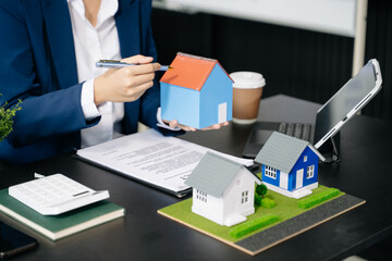 Real estate broker agent presenting and consult to customer to decision making sign insurance form agreement, home model,