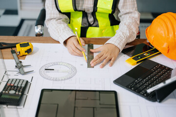 Businessman hand working and laptop with on on architectural project at construction site