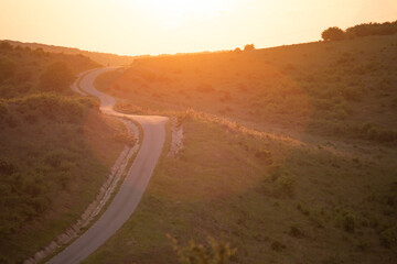 Long winding road in rural countryside leading off into distance.