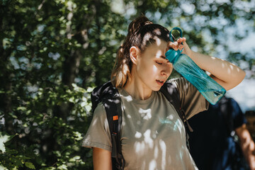 Young woman exploring nature with friends, carrying a backpack and hydrating with a water bottle. Enjoying a sunny day in the forest while hiking.