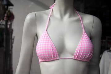 Closeup of pink bra of bikini on mannequin in a fashion store showroom