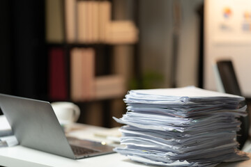 Close-up of businesswoman hands holding a pile of paperworks, sitting near the stack of documents...