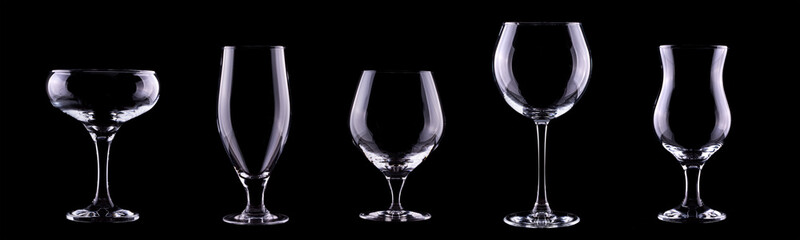 Set of different empty glasses for drinks and cocktails on black background