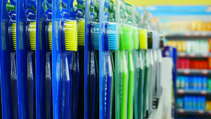 Many new colorful toothbrushes standing in a line in a supermarket
